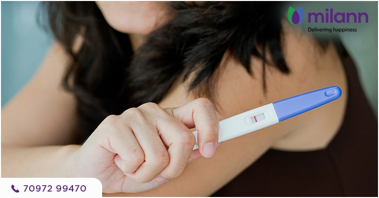 A woman holding a pregnancy testing stick.